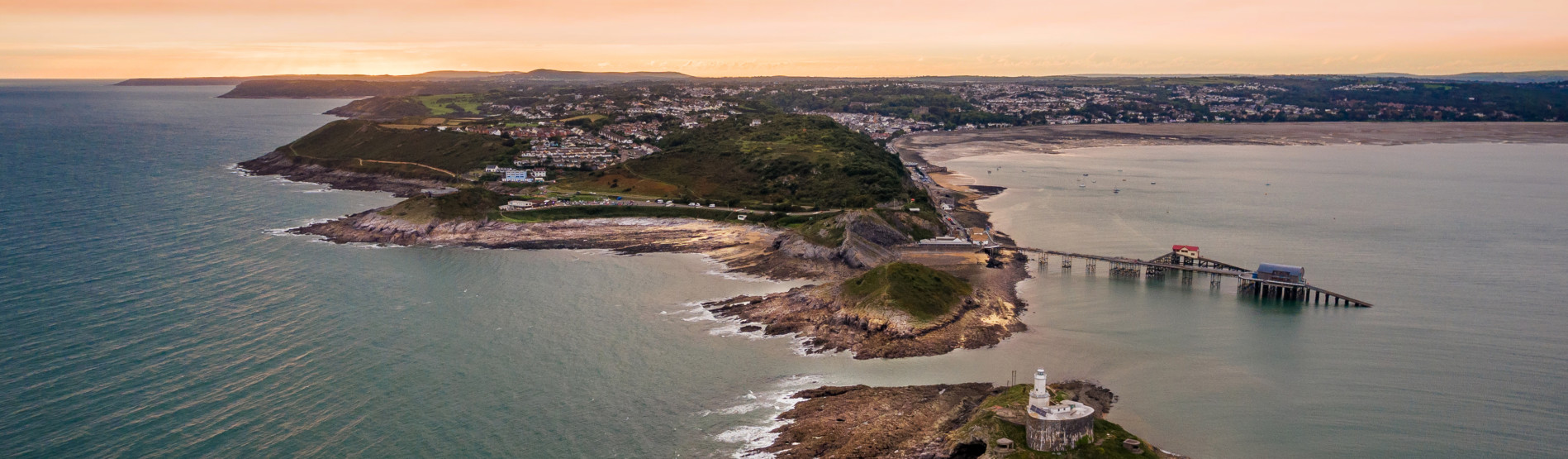 Image shows an aerial shot of Mumbles headland and lighthouse.